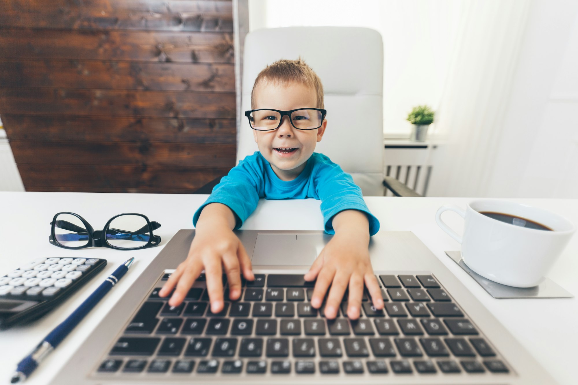 Cute child with glasses using a laptop